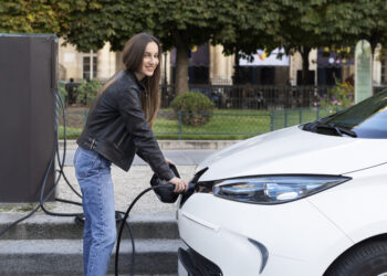 Femme qui recharge sa voiture électrique de location