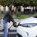 Femme qui recharge sa voiture électrique de location